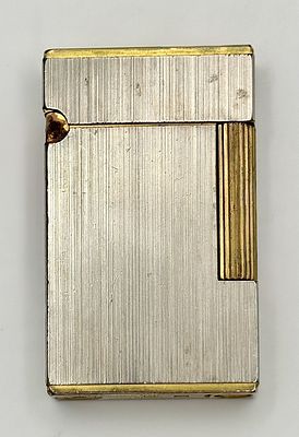 A Vintage S.T. Dupont Lighter. Silver and gold tone. Needs a flint and gas so as found. 6 x 