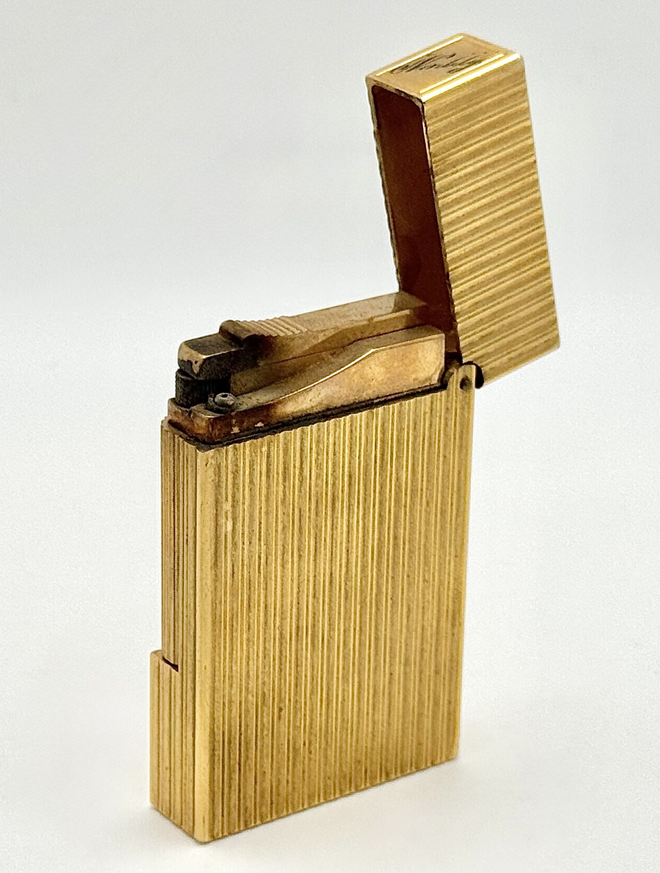 A Vintage S.T. Dupont Gold Plated Lighter with Vertical Pattern