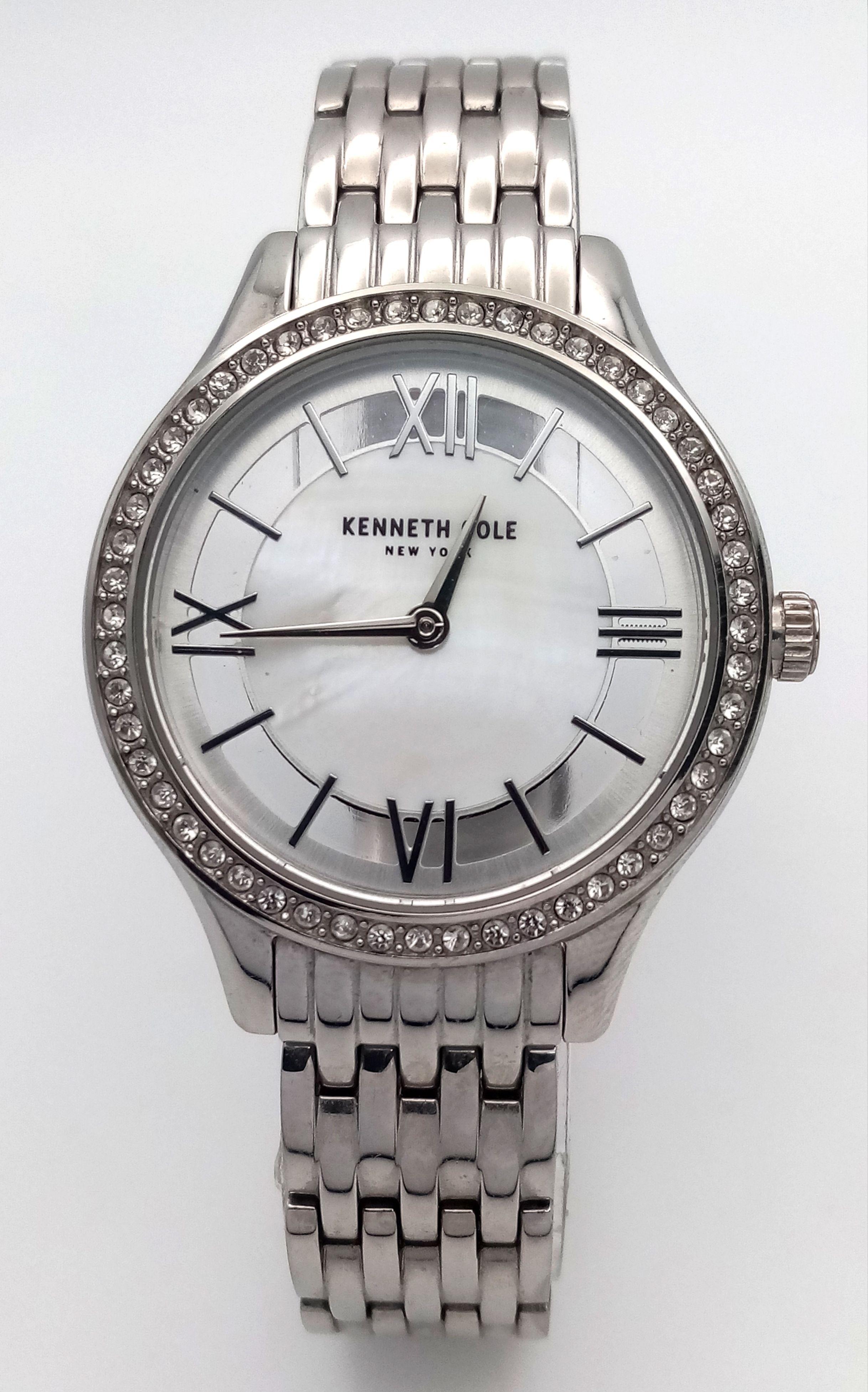 A KENNETH COLE, STONE SET BEZEL, STEEL BRACELET WATCH, WITH SKELETON BACK