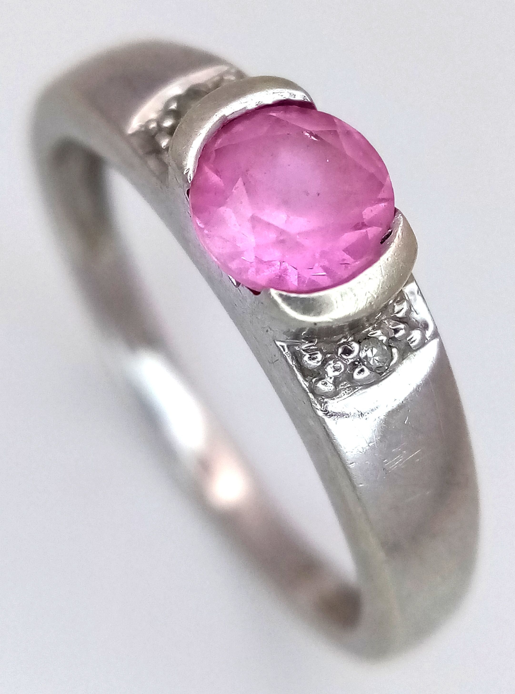 A 9K WHITE GOLD RING WITH AMETHYST CENTRE STONE FLANED BY 2 SMALL DIAMONDS