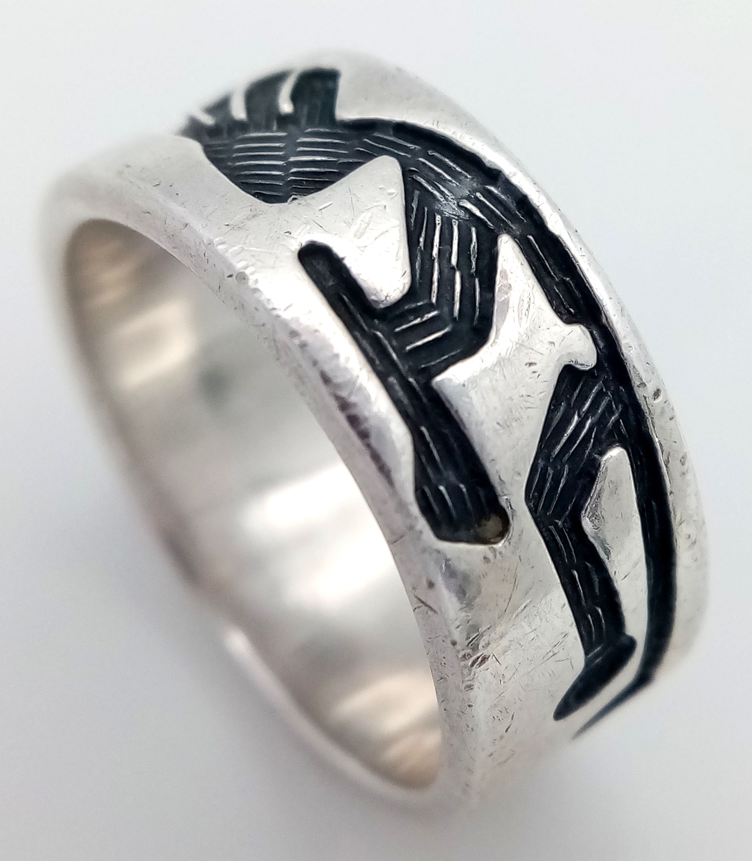 A SILVER BAND RING DECORATED WITH AZTEC FIGURES . 7gms size N