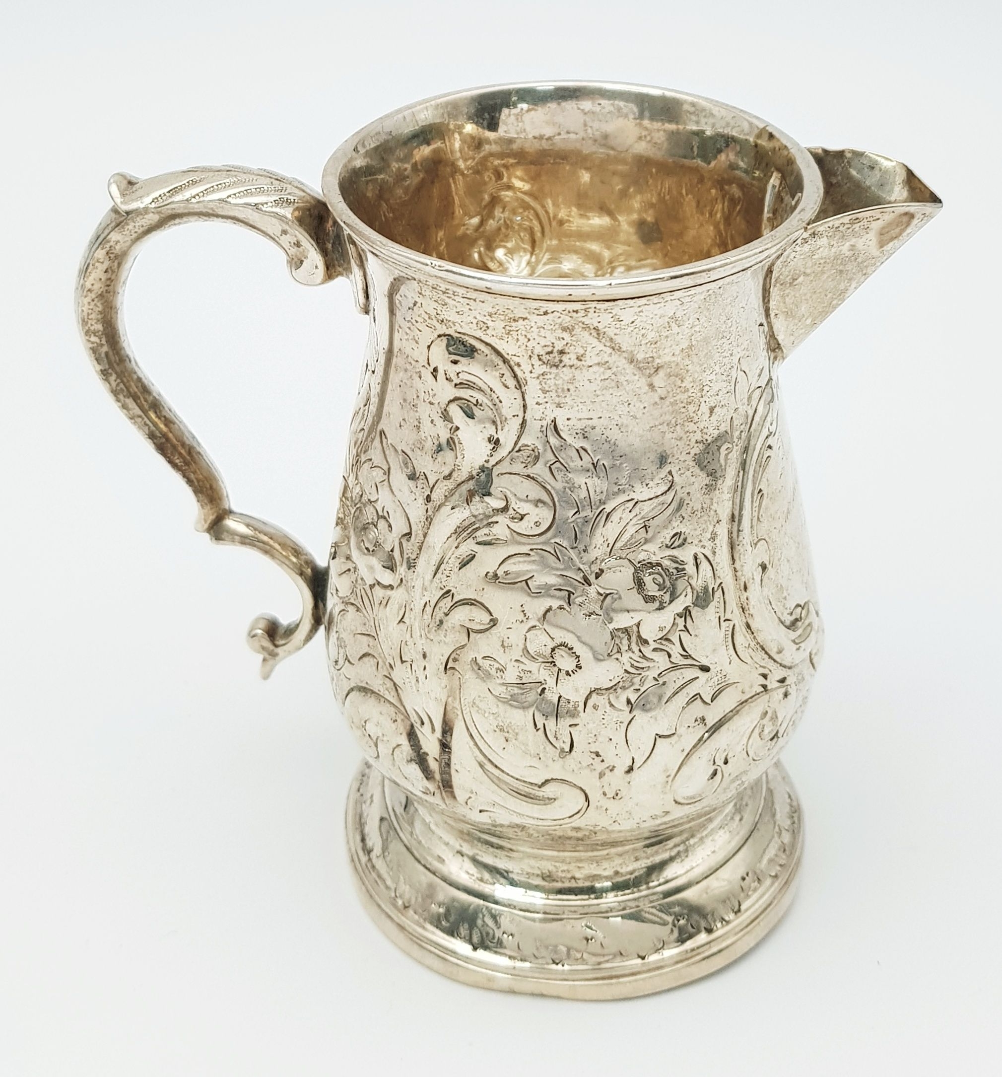 An Antique Georgian Creamer Jug Featuring Repoussé and Chased Decoration