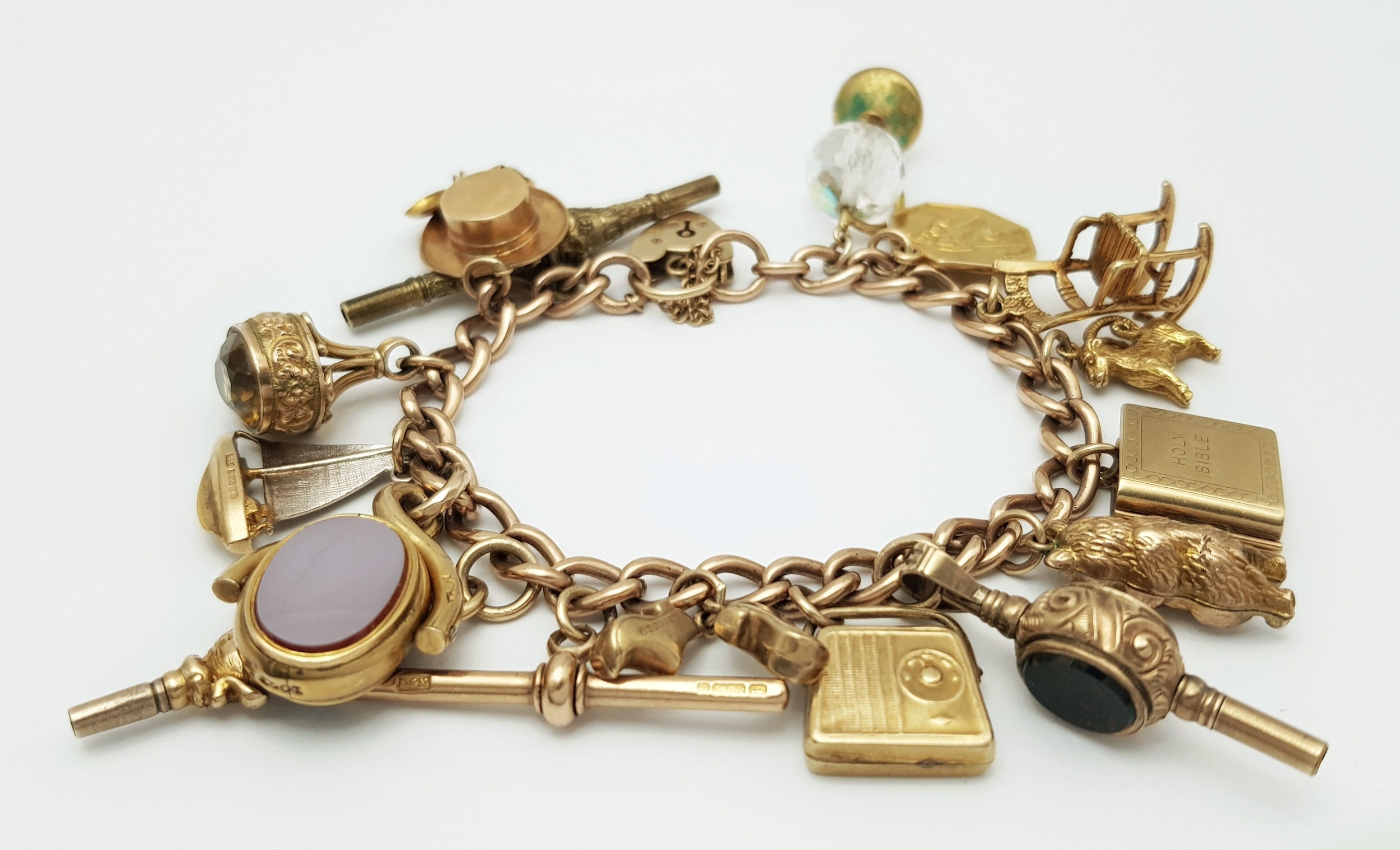 A vintage 9K yellow gold multi charms bracelet with heart padlock