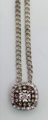 An 18K White Gold Diamond Pendant. Central diamond with a halo of champagne diamonds. A further 