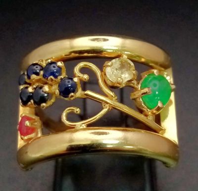 An 18 K yellow gold ring with an artistic design and adorned with an emerald cabochon, plus 