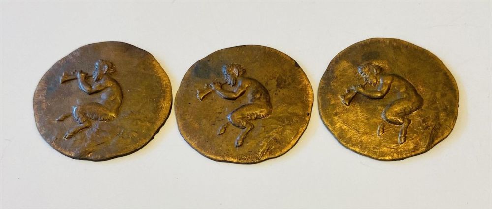 Lot 203: Copper medallions pan playing flute