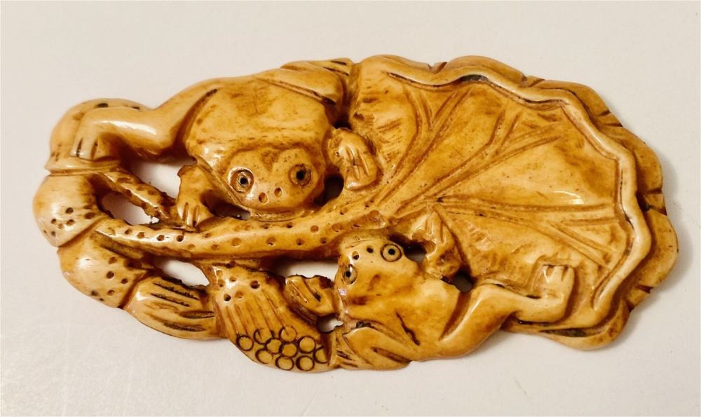 Lot 251: Frog carved bone /lily pad