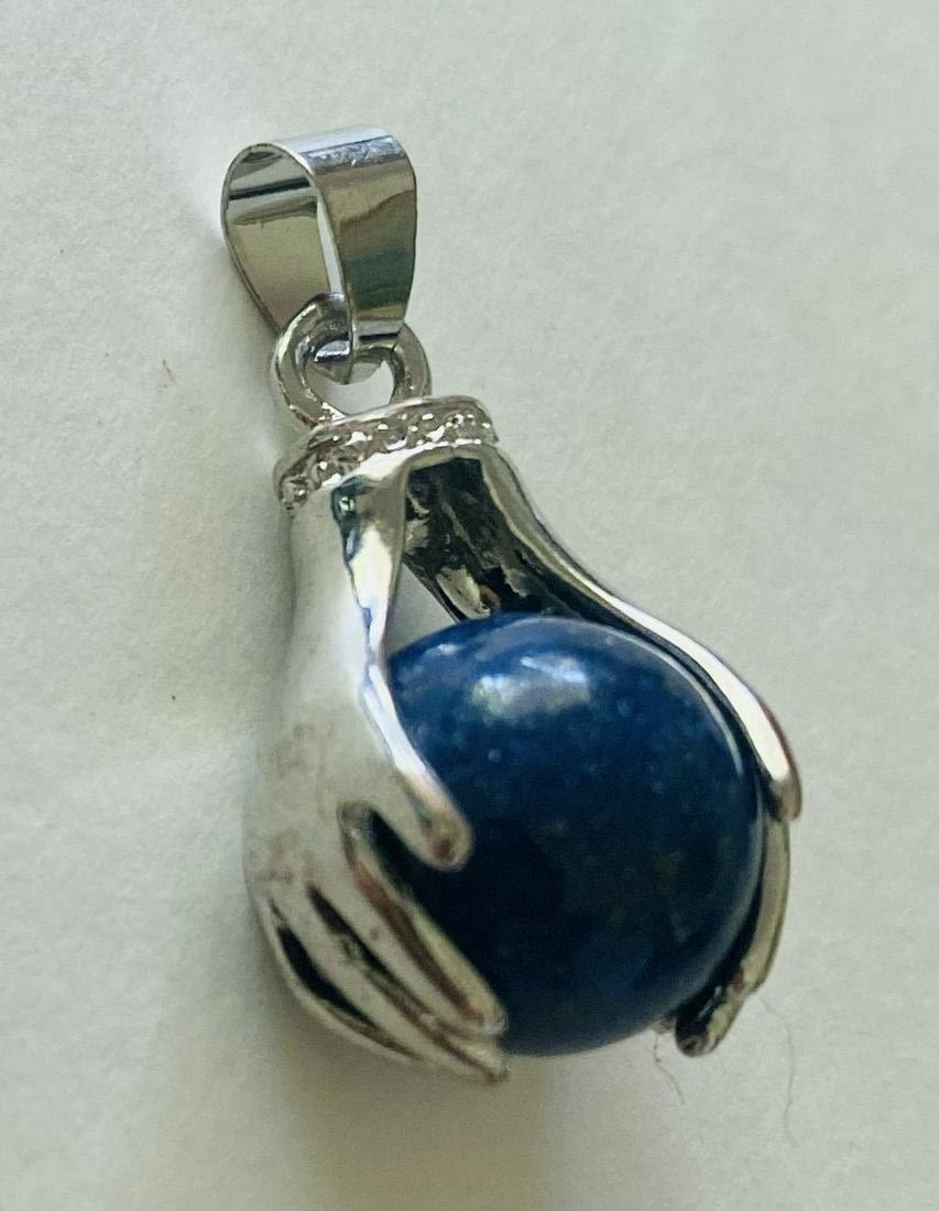 Lot 177: Blue lapis sphere /hands pendant