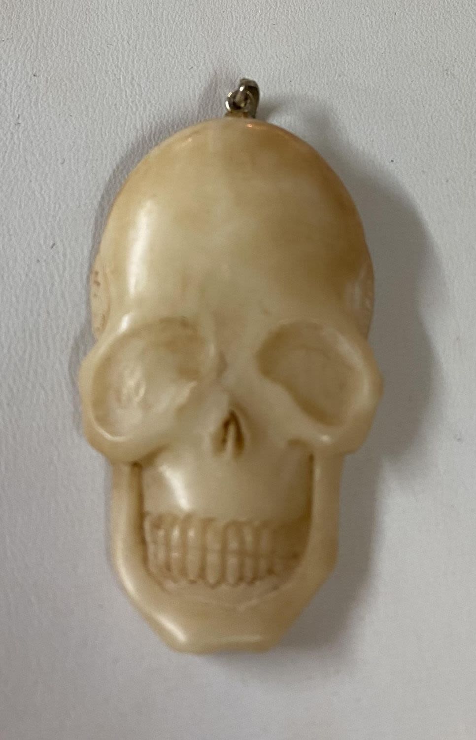 Lot 207: Bone carved skull face pendant