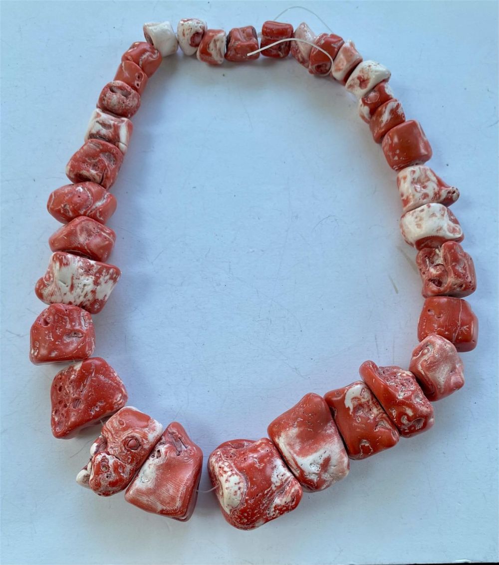Lot 223: Coral red drilled nugget strand