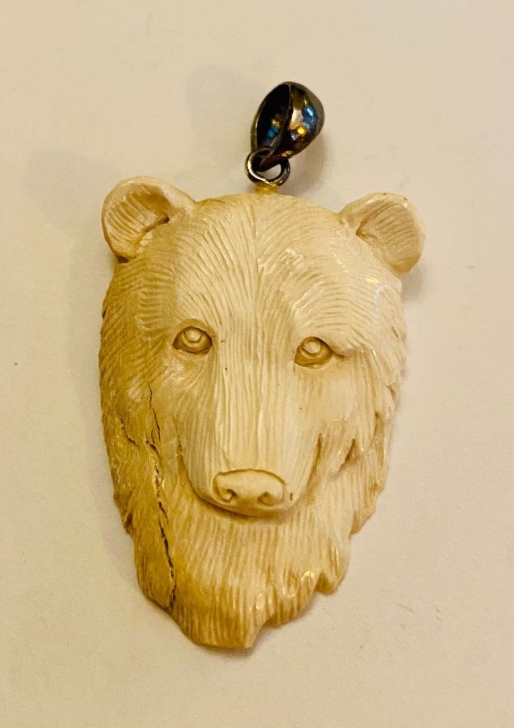 Lot 513: Carved bear head pendant