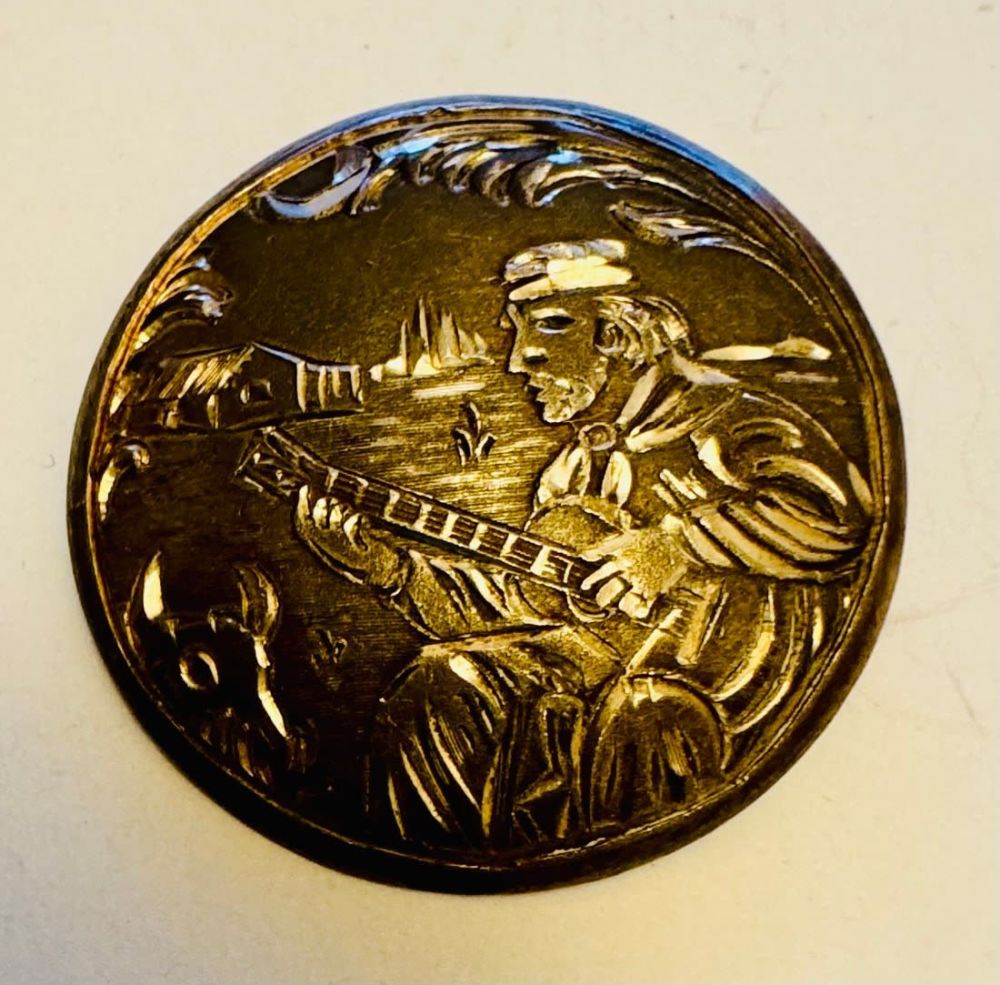 Lot 300: Round pin likely sterling with etched man seated