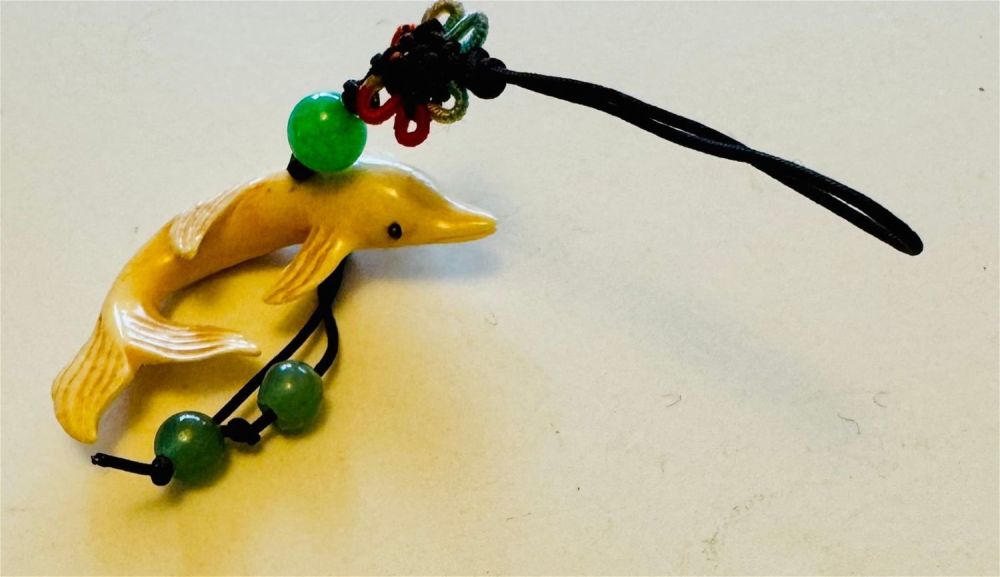 Lot 325: Dolphin carved bone charm/necklace