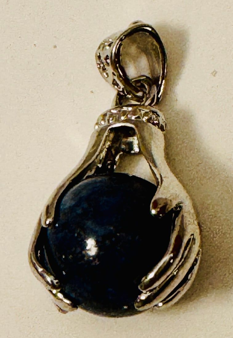 Lot 257: Lapis sphere held in hands pendant