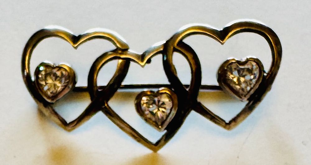 Lot 277: Triple heart sterling pin with clear heart stones.