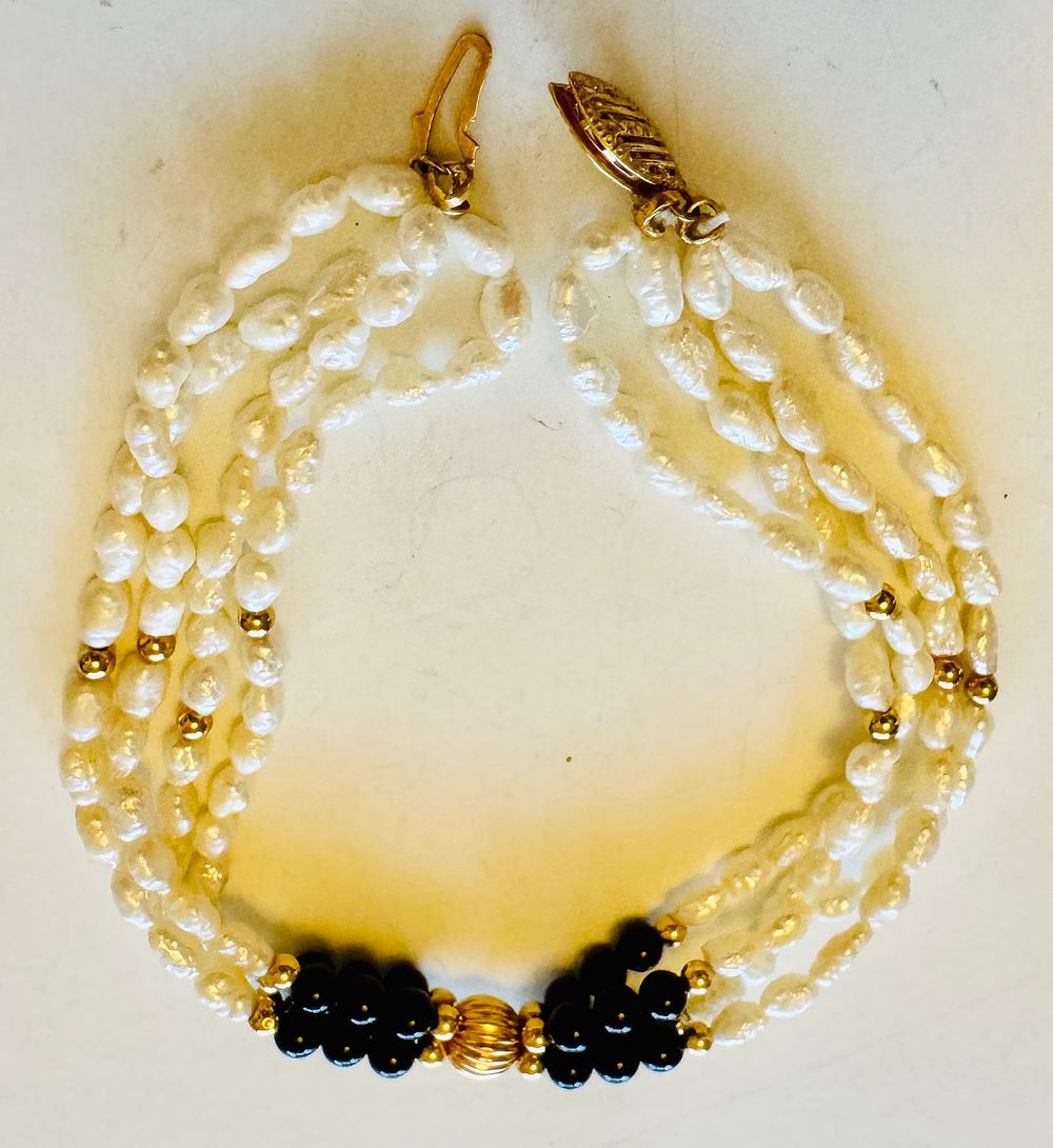 Lot 306: 14k triple rice pearl bracelet with onyx