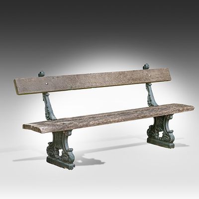 A garden bench on cast iron feet with a wooden slatted seat and back 97 x 220 x 56 cm. (38.1 x 