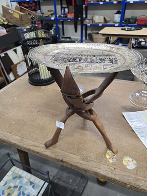 An Egyptian Revival Damascene Style Mixed-Metal Charger and a Carved West African Tripod Stand