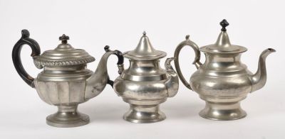 Three Pewter Teapots. Heights of all approximately 8 inches. Various dents and dings.