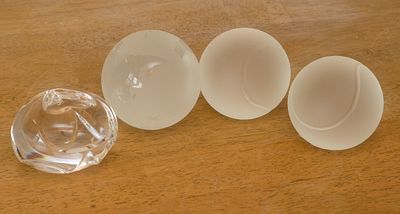 Four Glass Paperweights. Two Tiffany &amp; Co tennis balls, diameter 2.75 inches, Steuben, and 