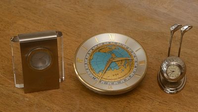 Three Desk Clocks. Imhof with world time zones, diameter 4.25 inches, Daniel David golf, and a 