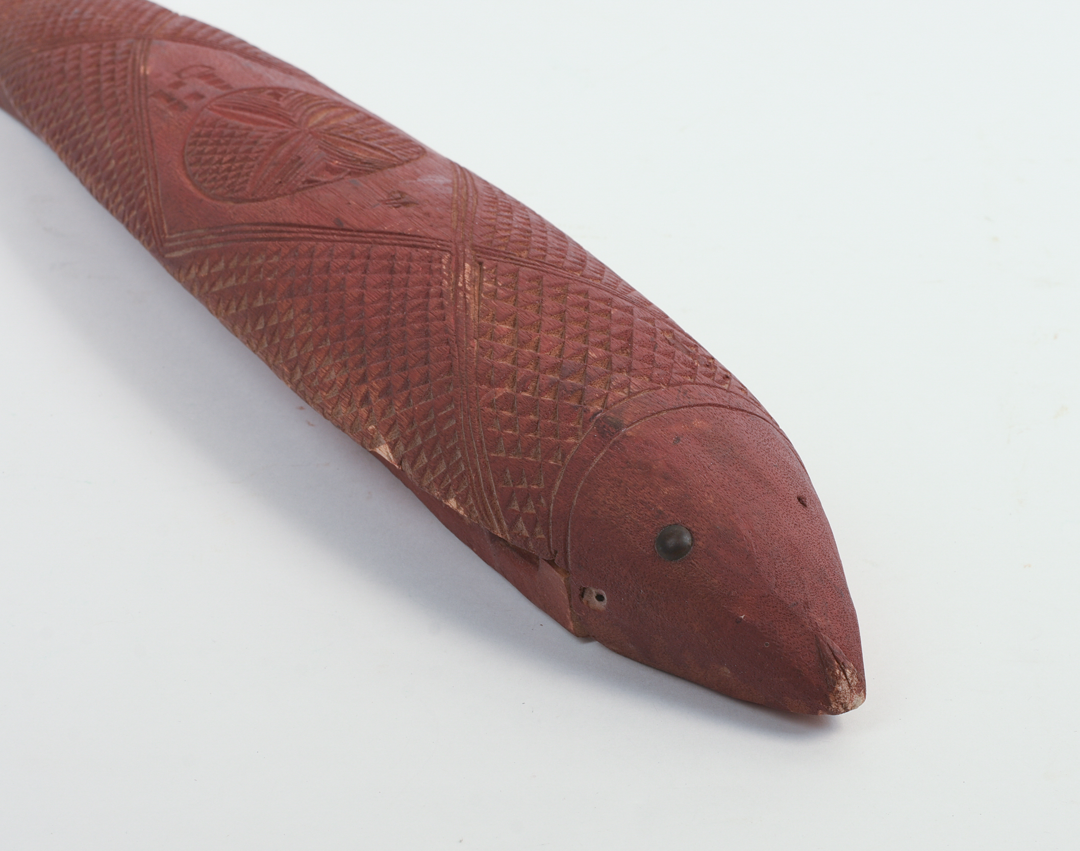 CHIP-CARVED FISH IN RED PAINT.