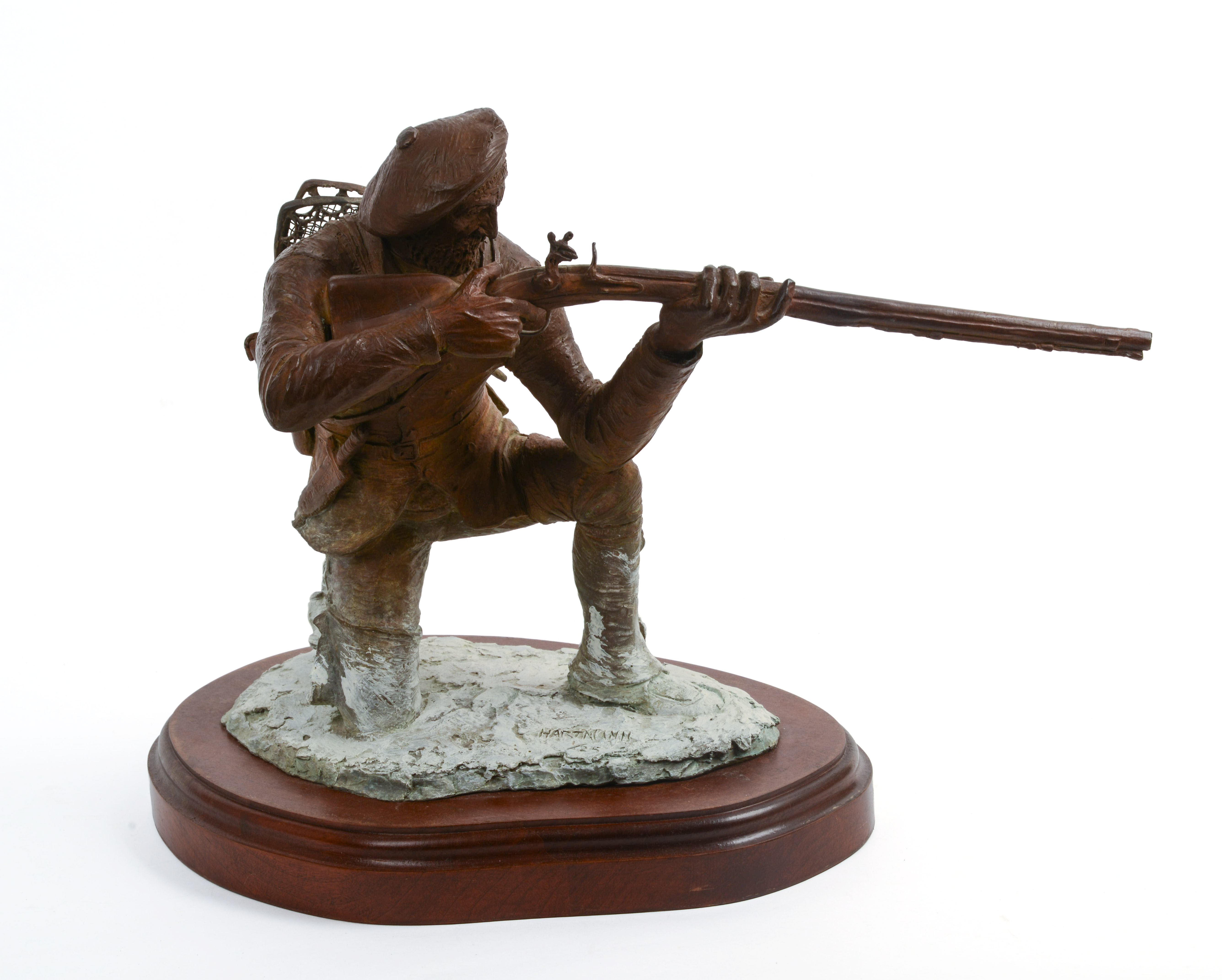 JUD HARTMANN (B. 1948). KNEELING FRENCH TRAPPER TAKING AIM.