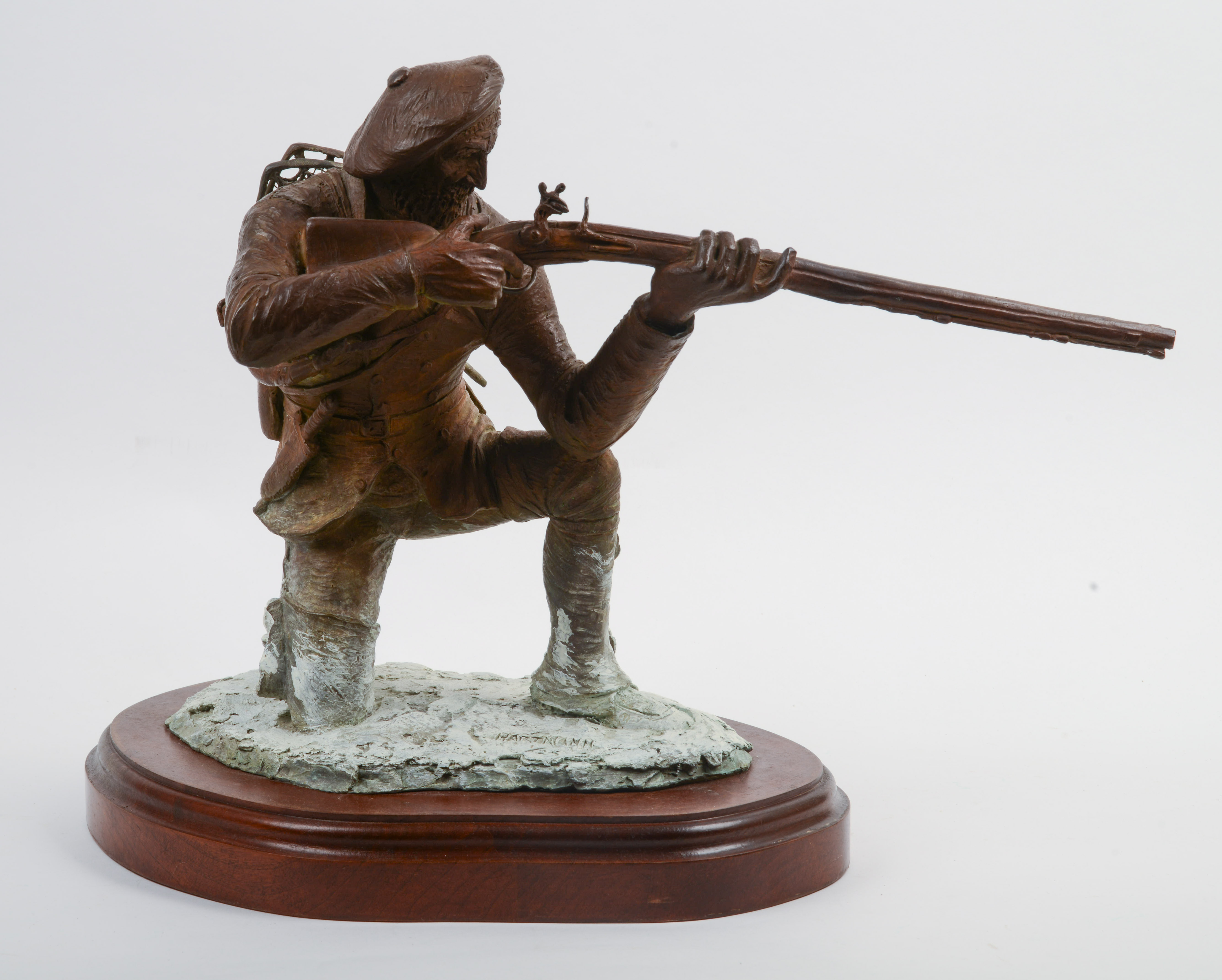 JUD HARTMANN (B. 1948). KNEELING FRENCH TRAPPER TAKING AIM.
