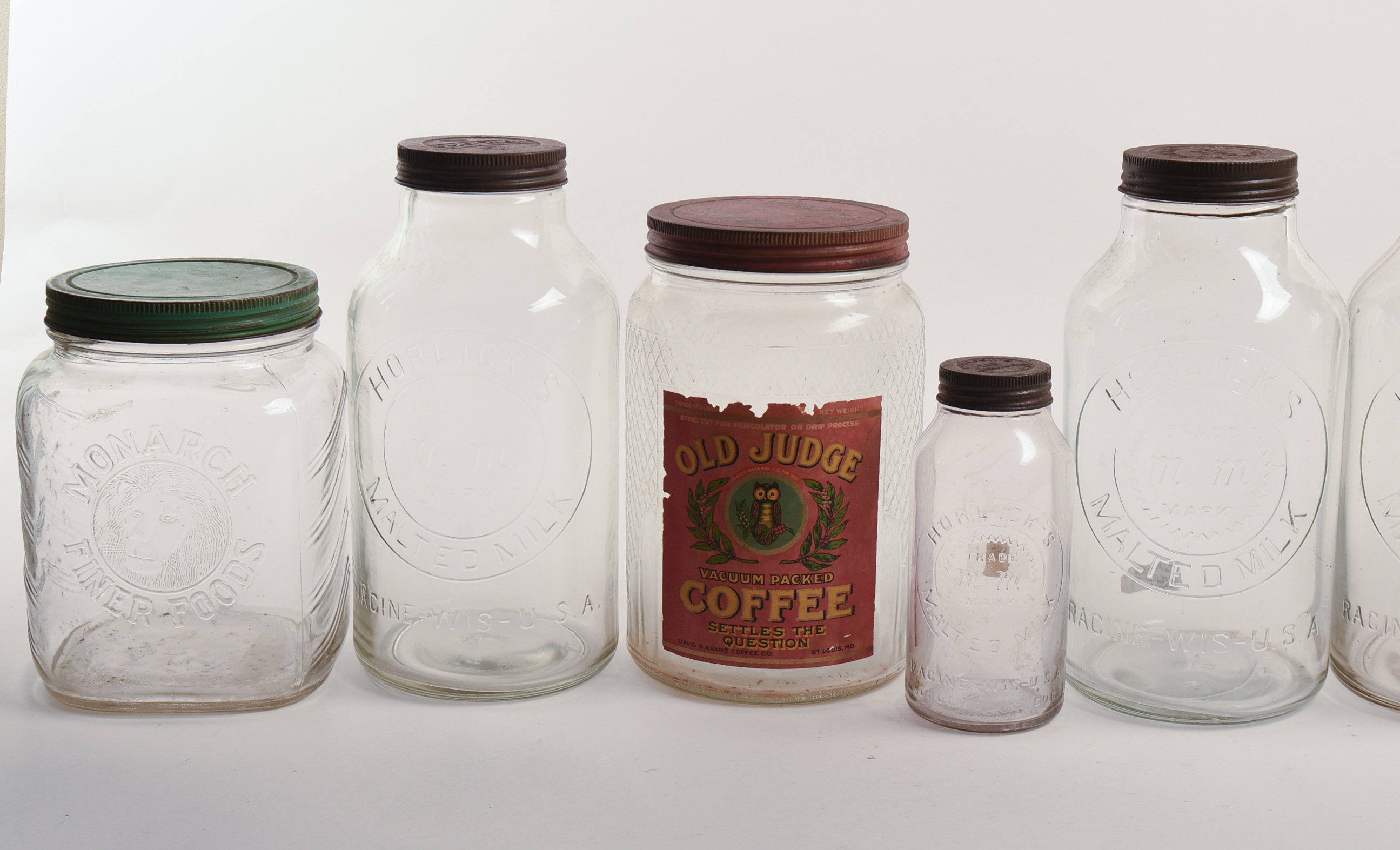 Eight Glass Advertising Jars.