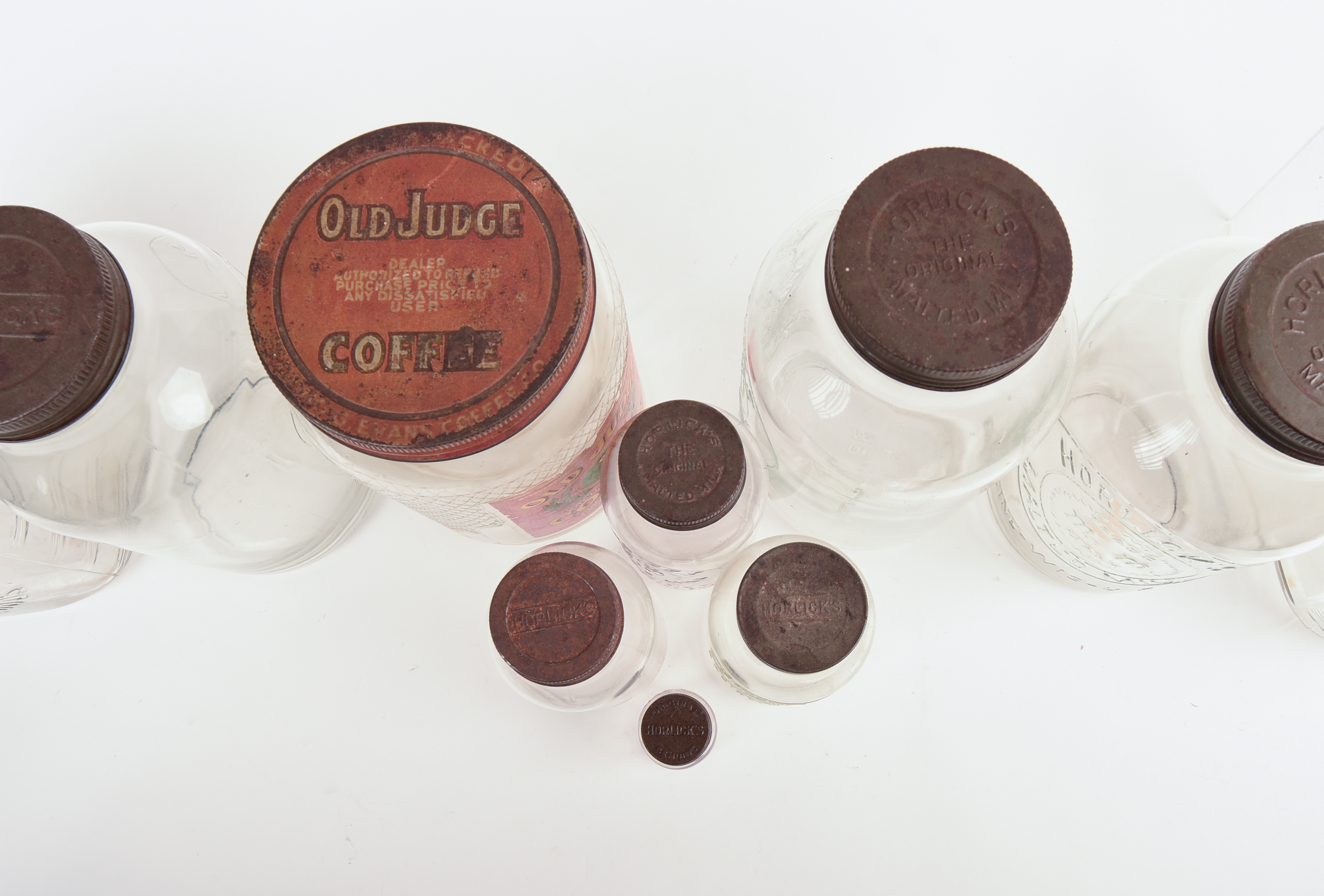 Eight Glass Advertising Jars.