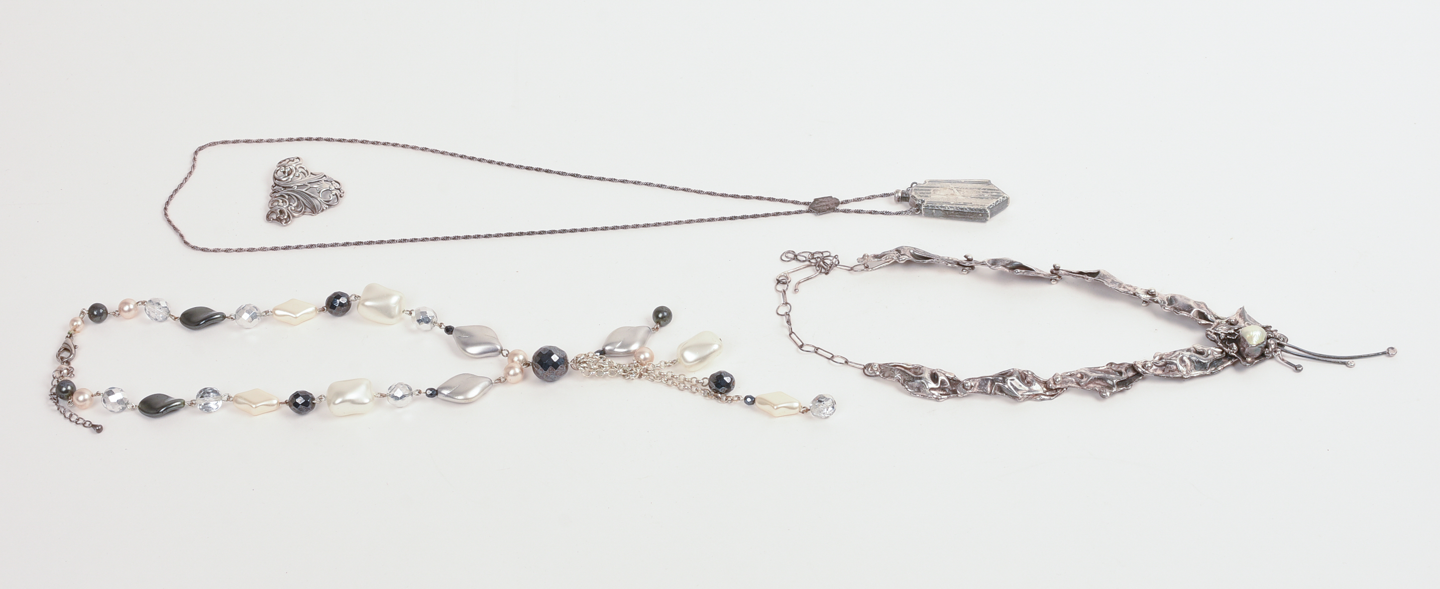 THREE NECKLACES AND A BROOCH.