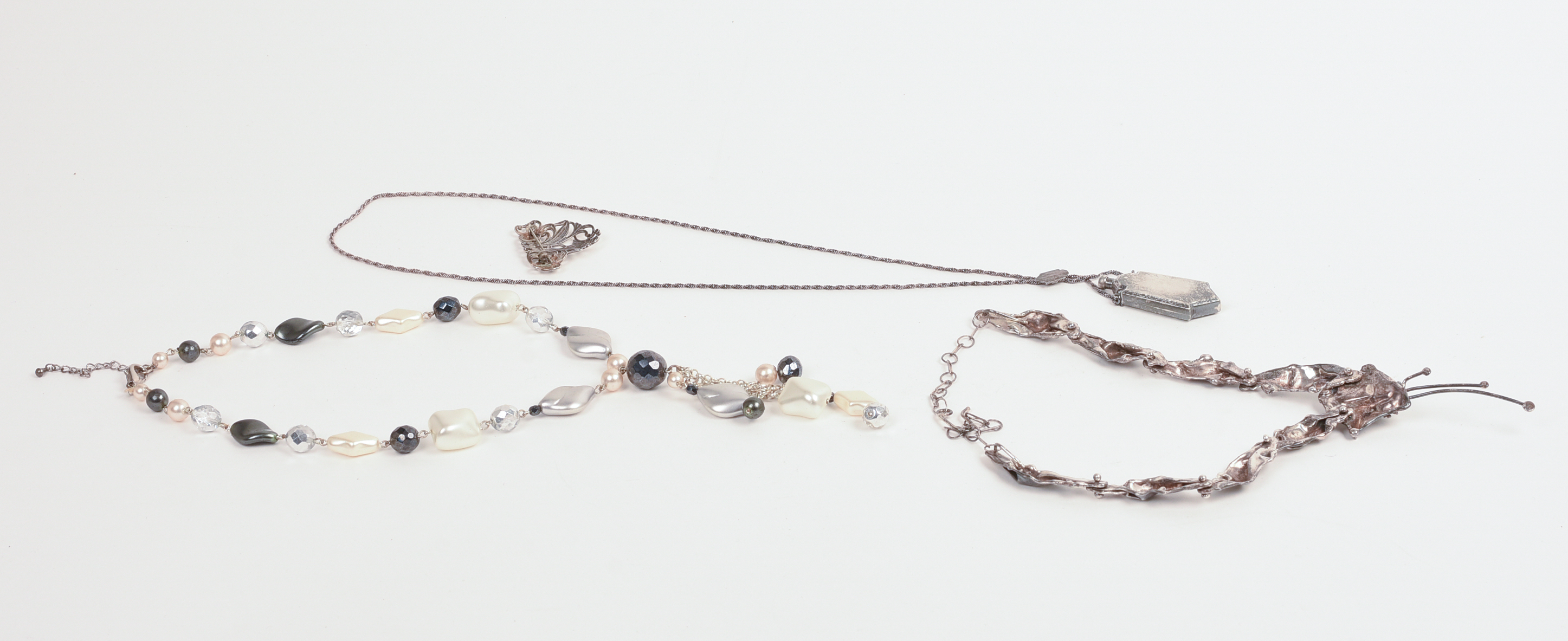 THREE NECKLACES AND A BROOCH.