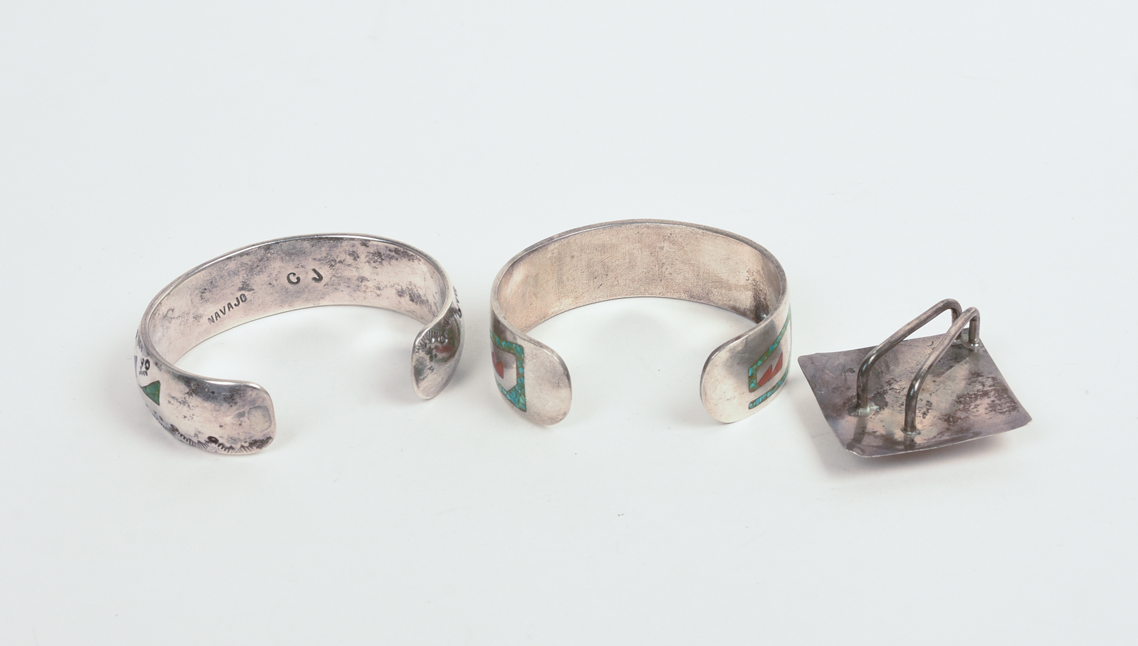 TWO NAVAJO CUFF BRACELETS AND A PENDANT.