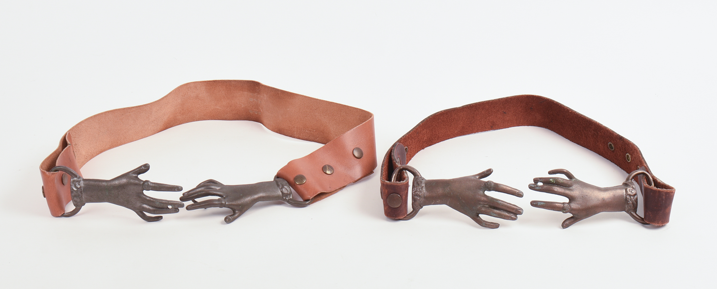 TWO BRASS AND LEATHER HAND BELTS.