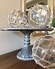 A Metal Cake Stand with Three Decorative Nautical-Style Glass Balls in Netting. This lot Image - 2
