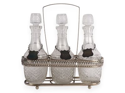 A Vintage Three-Bottle Glass Decanter Set in Silver-Toned Caddy. A vintage three-piece decanter 