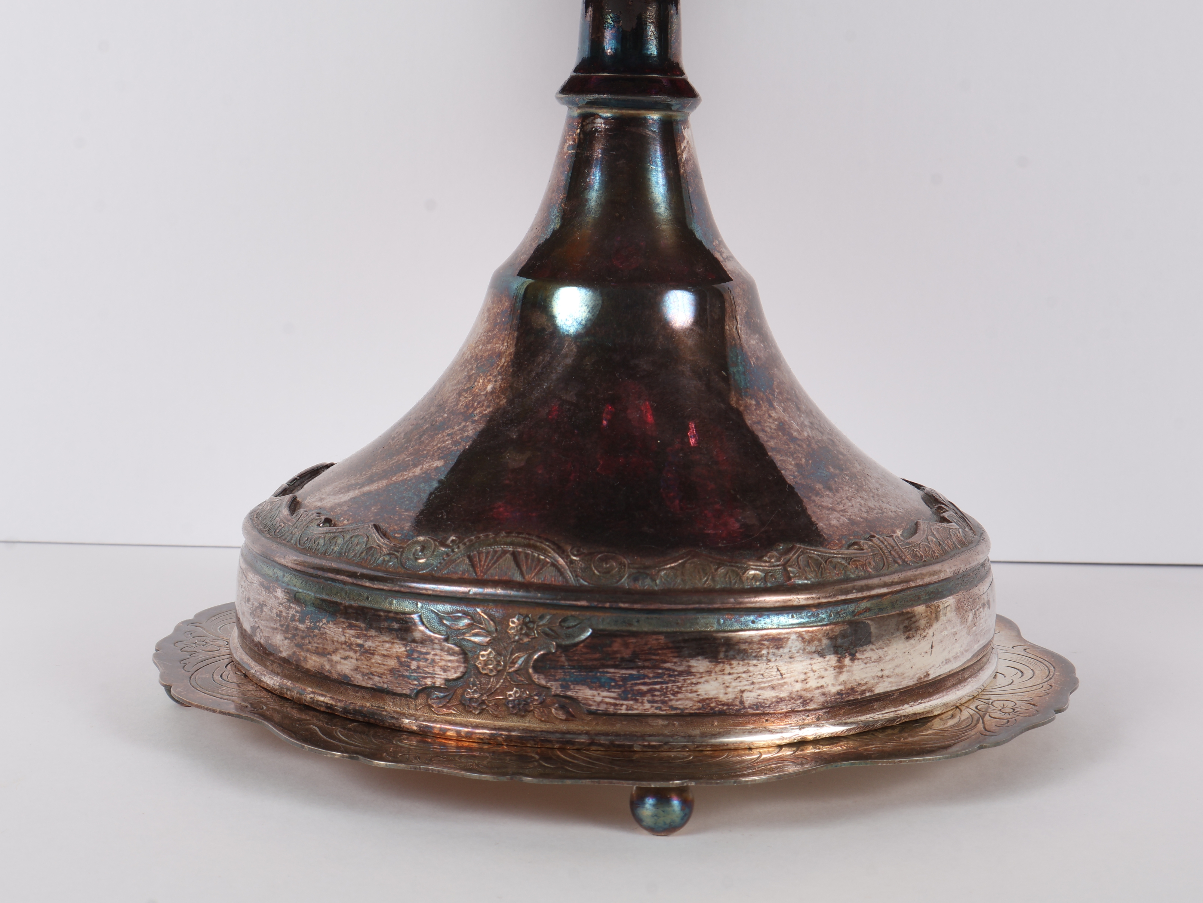 A Set of Five Victorian Cranberry Glass Bottles in an Ornate Silver-Plated Caster Stand