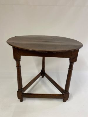 A Queen Anne oak Cricket Table of rare oval form. The boarded top supported by turned baluster 