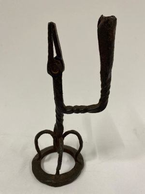 An 18th century wrought iron rush light holder with candle holder