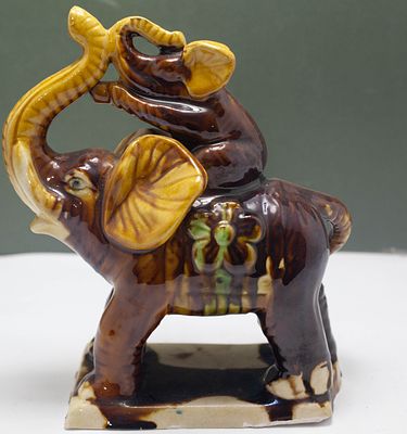 הפריט בתמונה הוא פסלון דקורטיבי של פיל גדול הנושא פיל קטן יותר על גבו