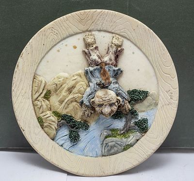 תבליט קיר עגול וינטג' סיני/יפני, דמות פולקלור מתהפכת בנוף הררי, פריט אספנות ייחודי