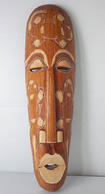 מסיכת קיר שבטית מגולפת בעץ: עבודת יד אמנותית עם עיטורי חיות ודמויות בתיחום נקודות לבנות