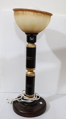 מנורת שולחן וינטג' בעלת בסיס עץ כהה המשלב אלמנטים מוזהבים, וזכוכית מעוטרת בגוון חום-דבש המפזרת 