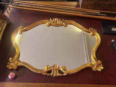 Baroque/Rococo style wall mirror . with a distinctive horizontal orientation and an ornate gilt 
