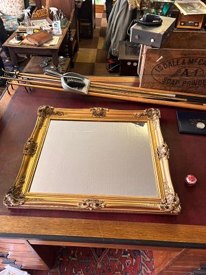 French-style mirror. features a heavy, ornate gold gilt frame designed in a Baroque or Rococo 