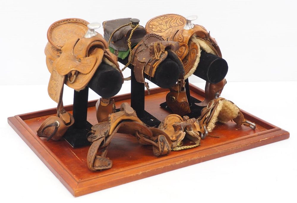 Lot 239: (7) Miniature leather saddles