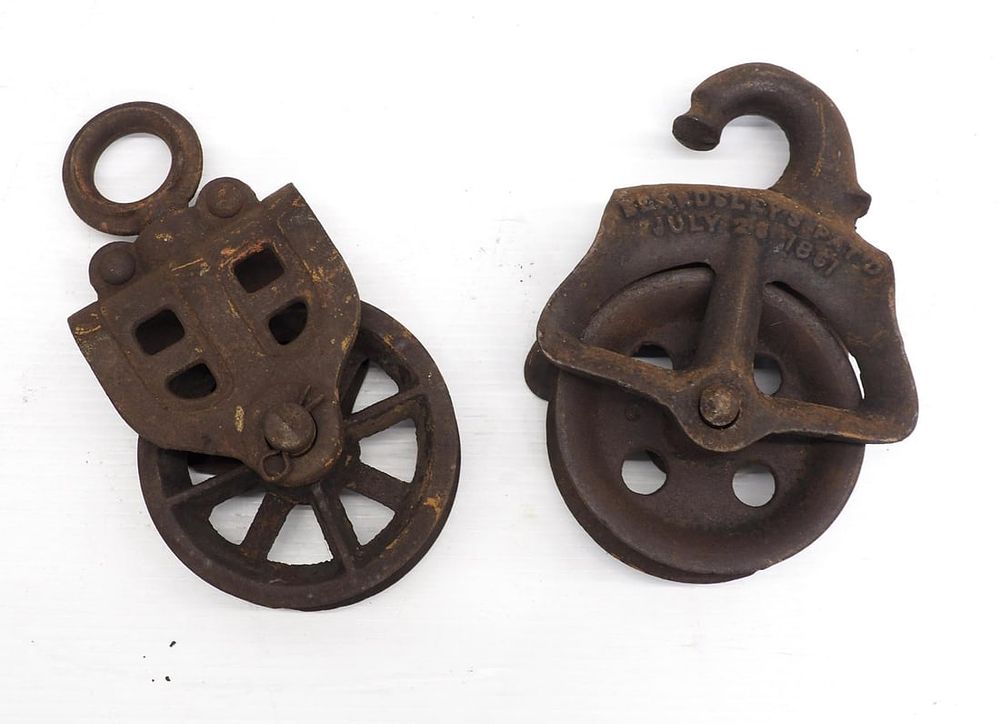 Lot 684: (2) Cast iron hay pulleys