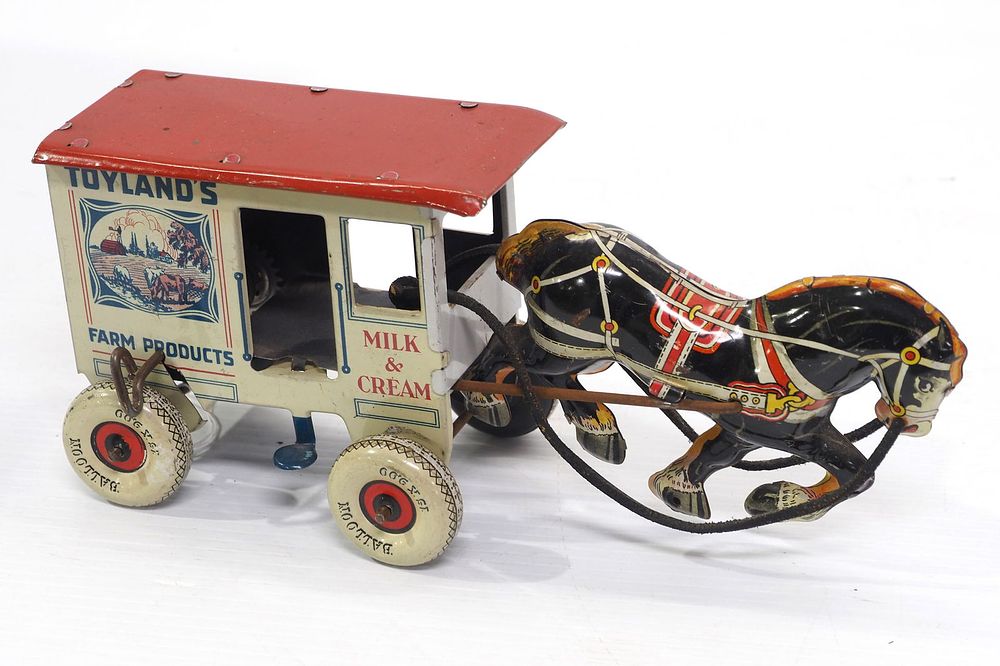Lot 1490: Tin horse-drawn milk wagon wind-up toy