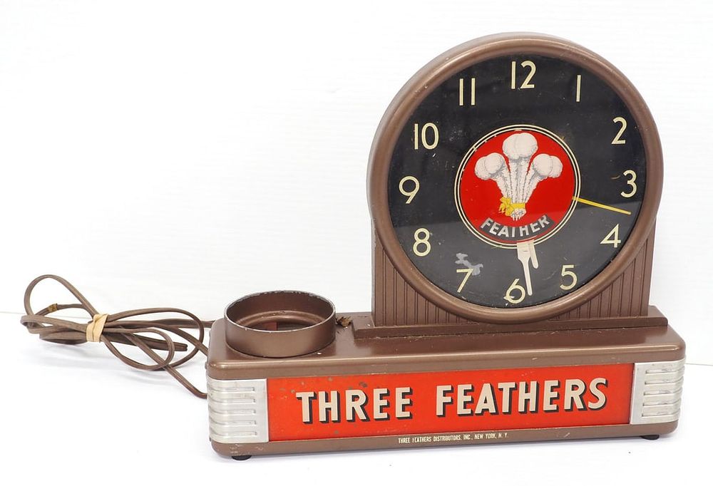 Lot 2412: Metal & glass lighted Three Feathers clock