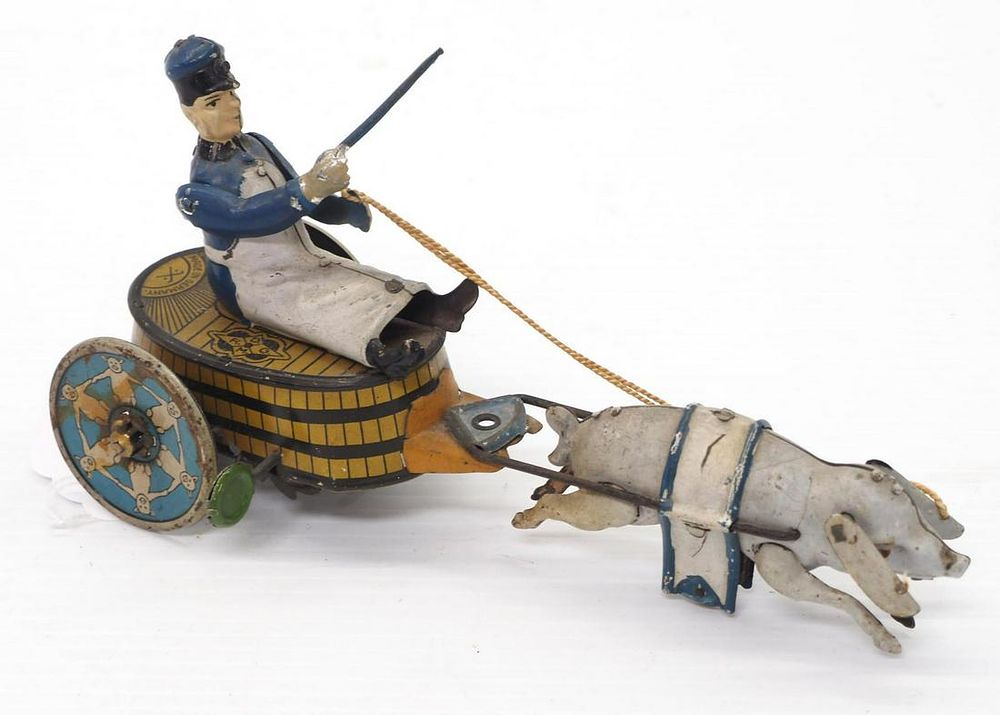 Lot 1272: Tin wind-up pig pulling butcher toy